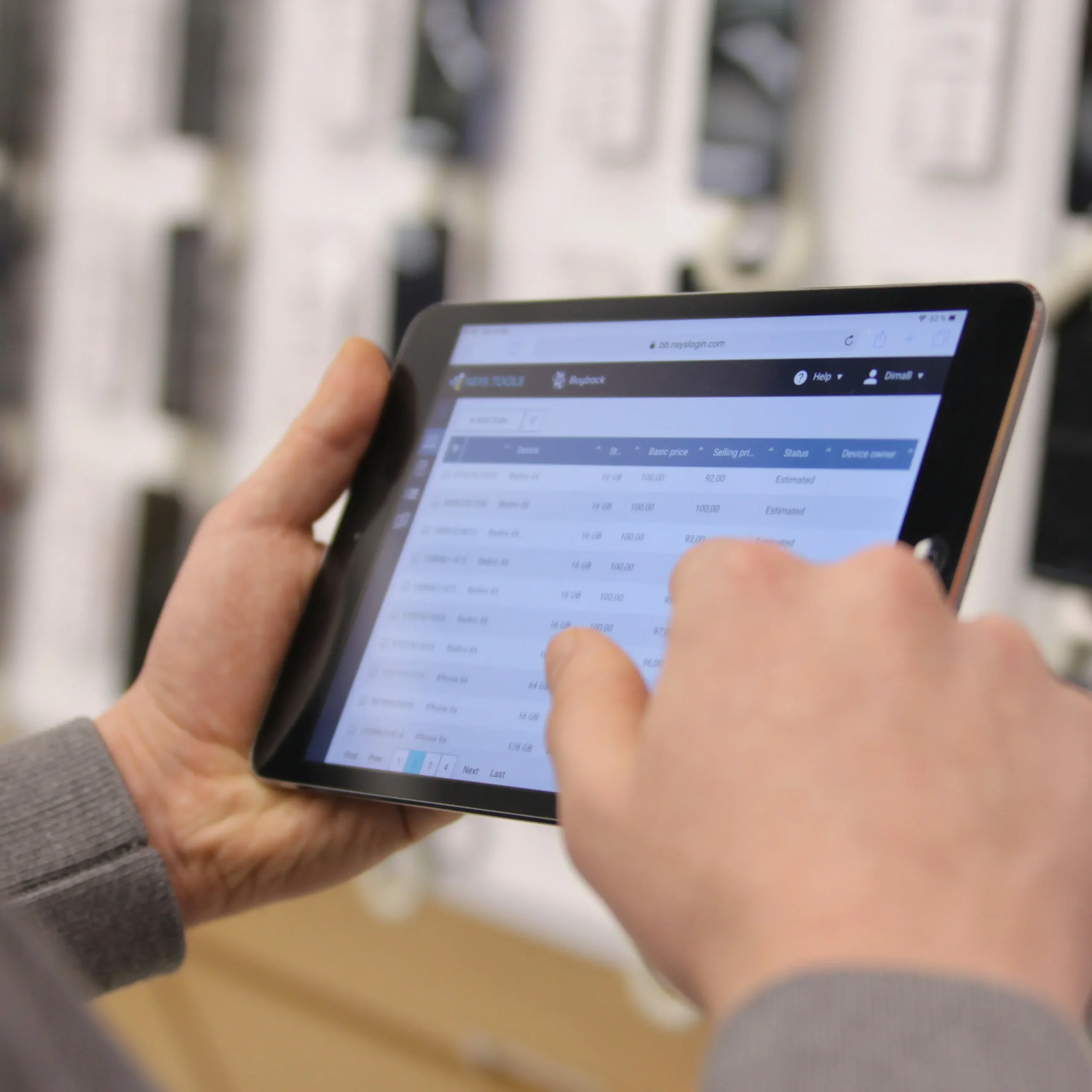 Handen bedienen een tablet met een lijst van data of instellingen op het scherm.